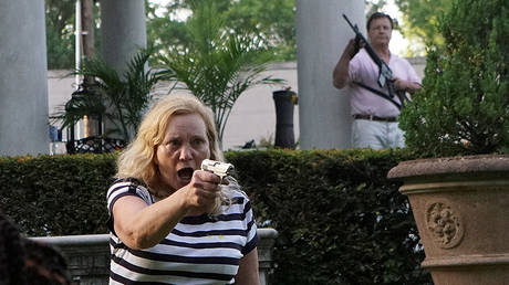 Mark and Patricia McCloskeys waved guns at protesters in front of their St. Louis home on June 28, after they were allegedly threatened. © REUTERS/Lawrence Bryant