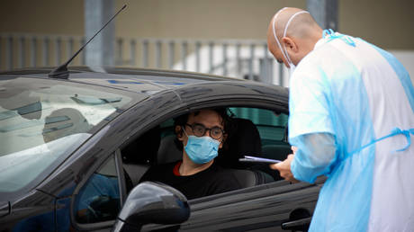 FILE PHOTO: A doctor checks the identity of a man before taking swabs. Toulouse. France. April 28th 2020