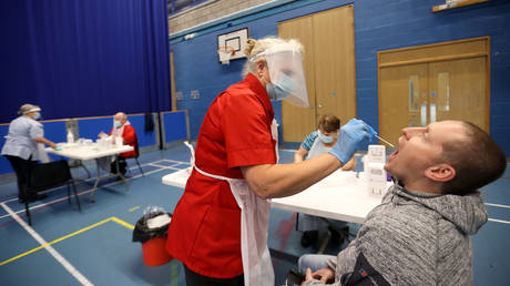 A health worker takes a swab from a man for COVID-19 test. © Reuters / Carl Recine