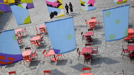 FILE PHOTO: People walk towards an empty socially distanced arranged outdoor seating area in London, Britain, September 11, 2020. © Reuters / Toby Melville