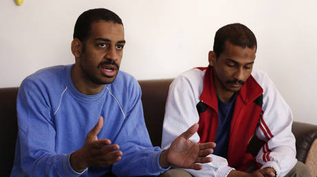 March 30, 2019, file photo. Alexanda Amon Kotey, left, and El Shafee Elsheikh speak during an interview with The Associated Press at a security center in Kobani, Syria. © AP Photo/Hussein Malla