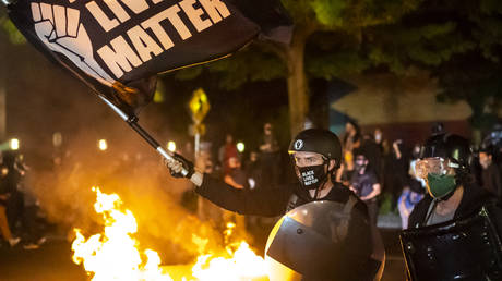 FILE PHOTO: Protesters gather in front of a fire near the North police precinct during a protest against racial injustice and police brutality on September 6, 2020 in Portland, Oregon