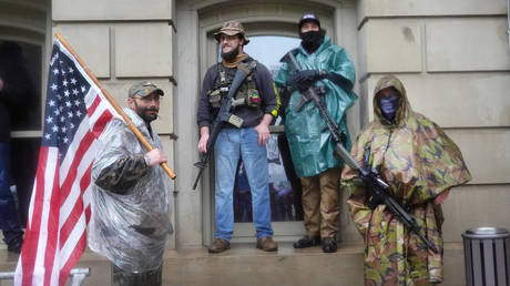 FILE PHOTO: Armed demonstrators attend a rally in front of the Michigan state capital building to protest the governor's stay-at-home order on May 14, 2020 in Lansing, Michigan