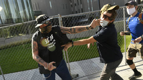 A man punches another man after a rally in Denver, Colorado. The man at right, then shot and killed the protester at left. © The Denver Post via Getty Images / Helen H. Richardson / MediaNews Group