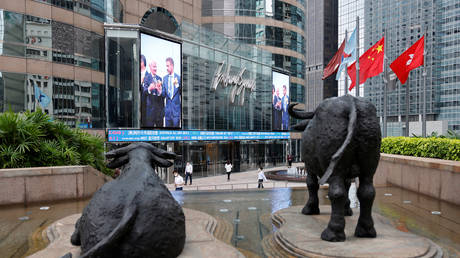 FILE PHOTO: Chinese and Hong Kong flags next to bull statues outside the Hong Kong Exchanges © Reuters / Tyrone Siu
