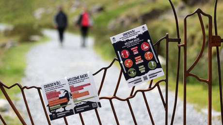 Informational signs hang on a gate in the Pen y Pass at the foot of Mount Snowdon, near Llanberis, Wales, Britain, July 11, 2020. © Reuters / Carl Recine / File Photo