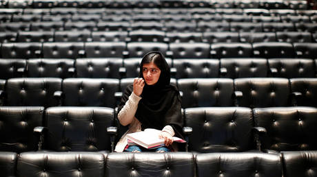FILE PHOTO: Malala Yousafzai signs a copy of her book before an event launching her memoir, "I Am Malala", at the Southbank Centre in central London, Britain, October 20, 2013