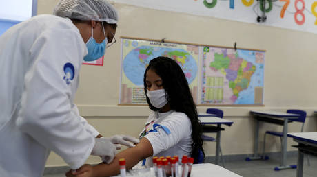 FILE PHOTO: A medical worker prepares to take a blood sample from a student for a Covid-19 test at a school in Sao Paulo, Brazil October 1, 2020. © Reuters/Amanda Perobelli