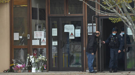 Flowers are seen at the entrance of the middle school in Conflans-Sainte-Honorine, 30kms northwest of Paris, on October 17, 2020.