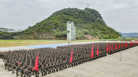 More than 1,000 officers and soldiers sit and listen during a new recruit mobilization conference in Nanning, Guangxi province, China, Oct. 10, 2020