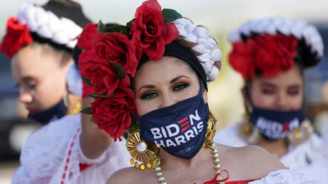 Dancers from a local Mexican dance company wear Biden/Harris face masks during a drive-in campaign event in Nevada