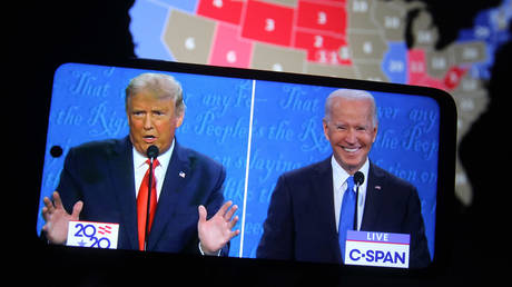 Donald Trump and Joe Biden are seen during the final presidential debate displayed on a screen of a smartphone