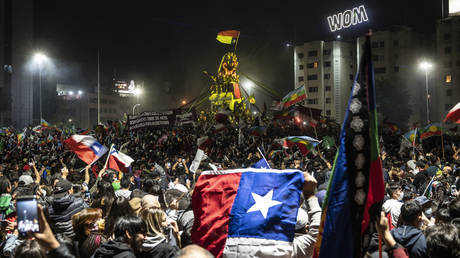 Demonstrators supporting the reform of the Chilean constitution celebrate while waiting for the referendum official results at Plaza Italia square in Santiago on October 25, 2020.