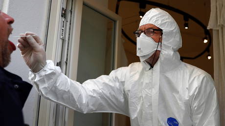 FILE PHOTO: A medical staff member collects a swab sample to be tested for the coronavirus as the COVID-19 spread continues, in the Mitte district of Berlin, Germany, October 28, 2020.