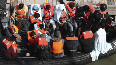 FILE PHOTO: A group of people, thought to be migrants wait on a Border Force rib to come ashore at Dover marina in Kent, England after a small boat incident in the English Channel, Tuesday Sept. 22, 2020.