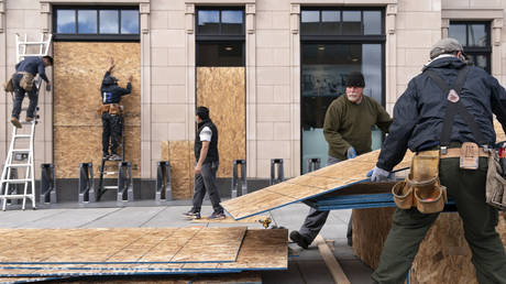 Workers board up a Walgreens in Washington, DC. © AP Photo/Jacquelyn Martin