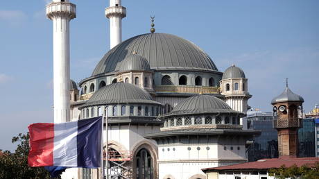 FILE PHOTO: A French flag flutters above the French Consulate, with a new mosque under construction in the background, in central Istanbul, Turkey