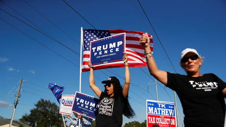 Supporters of US President Donald Trump campaign near a polling station on election day, in Tampa, Florida, November 3, 2020.