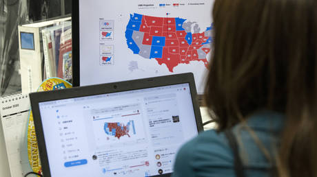 A foreign exchange trader looks at screens showing information on the US election as results are counted on November 4, 2020 in Tokyo, Japan.