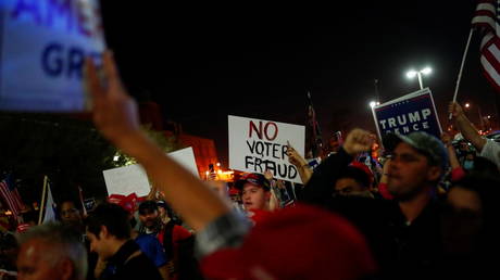 Supporters of U.S. President Donald Trump hold signs as they gather in front of the Maricopa County Tabulation and Election Center (MCTEC) to protest about the early results of the 2020 presidential election, in Phoenix, Arizona November 4, 2020.