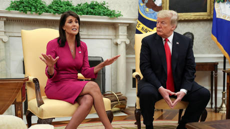 FILE PHOTO: US President Donald Trump listens to then-UN Ambassador Nikki Haley in the Oval Office following her announced resignation, October 9, 2018.