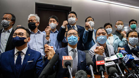 Opposition lawmakers join hands at a press conference in a Legislative Council office in Hong Kong on November 11, 2020. © Anthony Wallace / AFP