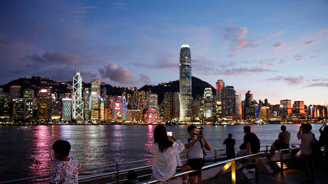 FILE PHOTO: People enjoy the sunset view with a skyline of buildings during a meeting on national security legislation, in Hong Kong, China June 29, 2020