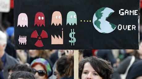 FILE PHOTO: A protester holds a sign reading "Game over" as he takes part in the "March of The Century" (La Marche du Siecle) to demand answers to climate change on March 16, 2019 in Paris