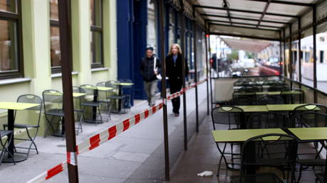 People walk next to abandoned tables of a restaurant as the coronavirus disease outbreak continues in Vienna, Austria on November 13, 2020.