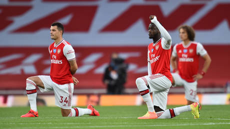 Arsenal players take a knee before their game against Liverpool in July. © Reuters