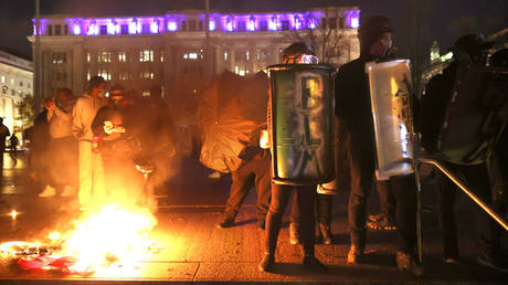 Black Lives Matter protesters hold shields as they stand next to a small fire during a protest following the “Million MAGA March” from Freedom Plaza to the Supreme Court, on November 14, 2020 in Washington, DC