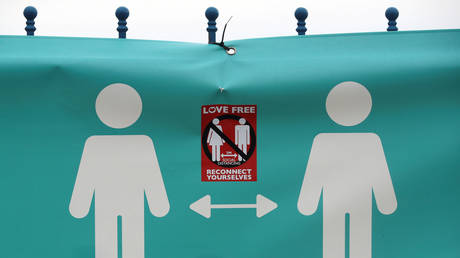 FILE PHOTO: An anti-social distancing sticker is seen on a social distancing banner, in Llandudno, Britain October 19, 2020.