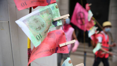 FILE PHOTO: Fake banknotes, called "dirty money", are seen as Extinction Rebellion climate activists stage a protest during a "peaceful disruption" of UK parliament as lawmakers return from the summer recess, London, Britain September 9, 2020