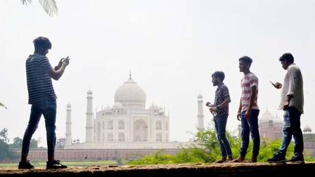 People take pictures with their mobile phones near the Taj Mahal in Agra on September 8, 2020. © AFP / Pawan Sharma