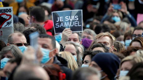 FILE PHOTO: People gather at the Place de la Republique in Paris, to pay tribute to Samuel Paty, the French teacher who was beheaded on the streets of the Paris suburb of Conflans-Sainte-Honorine, France, October 18, 2020.