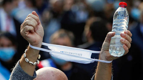 A demonstrator holds a face mask as restaurants, cafes and bars owners protest against government closure measures during the coronavirus disease (COVID-19) outbreak in Marseille, France, November 26, 2020. © REUTERS / Eric Gaillard