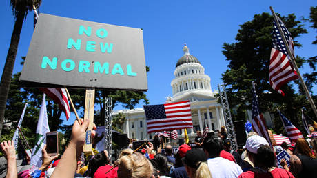 A protester holds a placard that says No New Normal during the demonstration outside the California State Capitol, May 23, 2020, Sacramento, California, United States