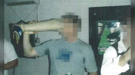 An Australian soldier drinks beer from a prosthetic leg that belonged to a Taliban fighter