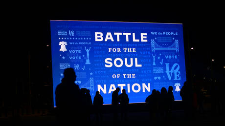 FILE PHOTO: Attendees are silhouetted in front a digital screen displaying a campaign message stating "BATTLE FOR THE SOUL OF THE NATION" before Democratic vice presidential nominee Sen. Kamala Harris (D-CA) speaks at a drive-in election eve rally on November 2, 2020 in Philadelphia, Pennsylvania