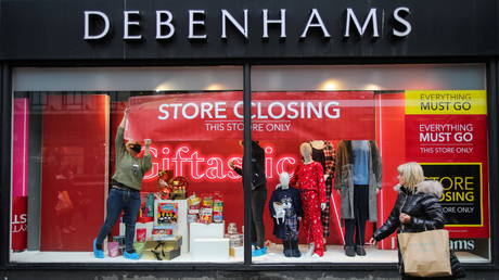 Members of staff attach a closing down sign in a window of Debenhams store, amid the outbreak of the coronavirus disease (COVID-19) in Manchester, Britain, December 2, 2020