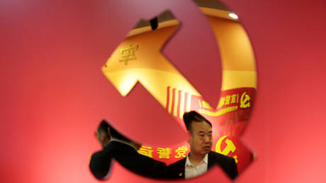 FILE PHOTO: Party members are reflected on a party emblem of the Communist Party of China (CPC) at Tidal Star Group's party activity room in Beijing, China, February 25, 2019