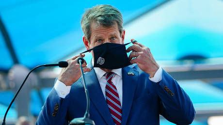 FILE PHOTO: Georgia Governor Brian Kemp puts on a mask after speaking at a press conference on August 10, 2020.