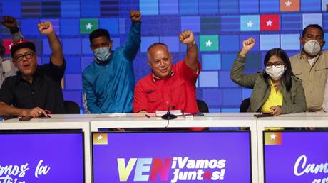 Members of the United Socialist Party of Venezuela raise their hands with a clenched fist in a sign of victory on December 7, 2020 in Caracas, Venezuela.