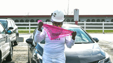A Tyson Foods employee puts on a second protective mask outside of the company's meat processing plant in Waterloo, Iowa