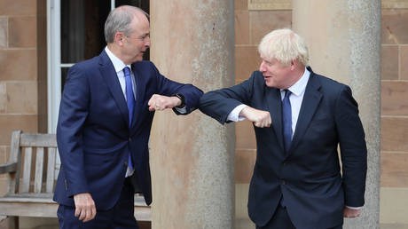 FILE PHOTO: Ireland's Taoiseach Micheal Martin (L) and UK PM Boris Johnson greet each other with an elbow bump in Belfast on August 13, 2020 © Brian Lawless/Pool via Reuters