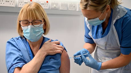 A medic receives the Pfizer COVID-19 vaccine on the first day of the largest immunisation programme in the British history, at the Louisa Jordan Hospital, in Glasgow, Scotland, Britain (FILE PHOTO) © Jeff J Mitchell/Pool via REUTERS