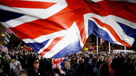 FILE PHOTO: A man waves a British flag on Brexit day in London, Britain. © REUTERS / Henry Nicholls