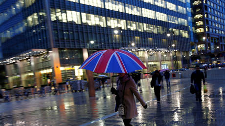 Workers walk in the rain at the Canary Wharf business district in London