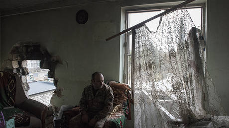A man sits in a house hit by shelling in the city of Martakert, Nagorno-Karabakh. © Sputnik / Valeriy Melnikov