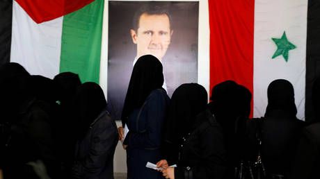 FILE PHOTO: Women stand as they wait their turn to cast the votes inside a polling station during the parliamentary elections in Douma, in the eastern suburbs of Damascus, Syria July 19, 2020